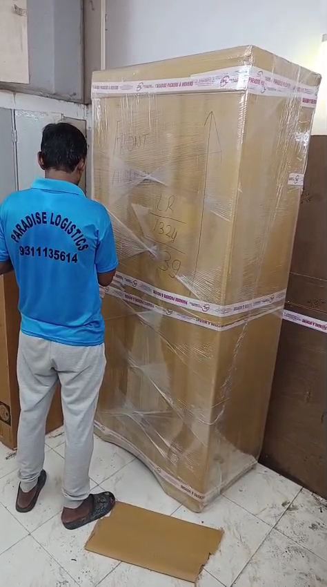 Paradise Packers and Movers worker packing a large household item